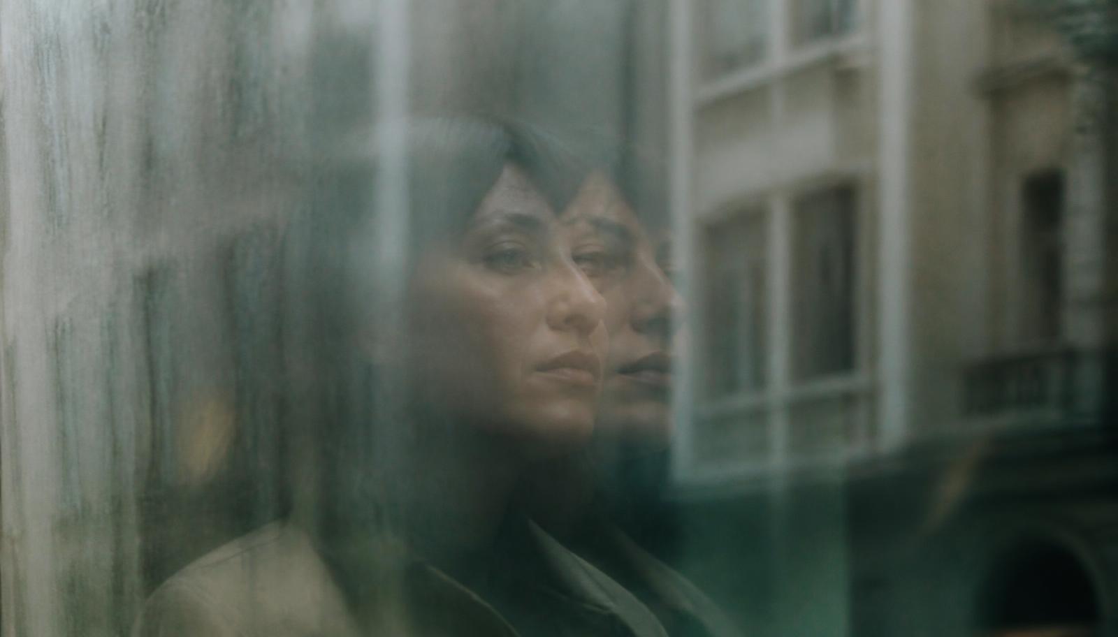 Retrato de una persona reflejada de forma difusa en el cristal de una ventana, evocando la sensación de irrealidad de la despersonalización